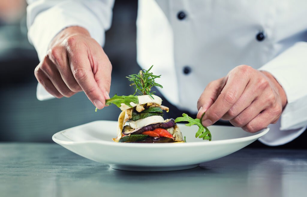 Chef garnishing plate of food